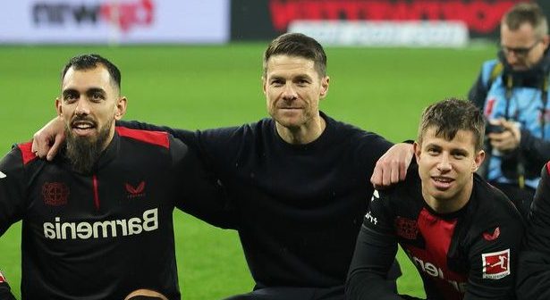Bayer Leverkusen head coach Xabi Alonso celebrates with his players in front of the fans after the Bundesliga match against Bayern Munich on February 10 2024